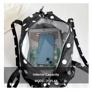 Vue détaillée de la capacité interne du sac à pois noir avec doublure blanche et tablette