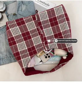 Macro view of the internal capacity of red plaid tote bag with everyday essentials