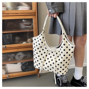 Detail of off-white polka dot nylon shoulder bag with a stylish ribbon bow attachment