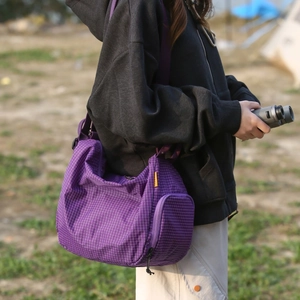 Détail du sac cabas en toile à carreaux violets avec bandoulière réglable et poche latérale