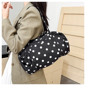 Gros plan du sac de voyage léger à pois noirs et blancs sur l'épaule du mannequin