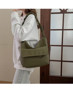 Detail view of olive green nylon shoulder bag with wide pleated strap in minimalist style