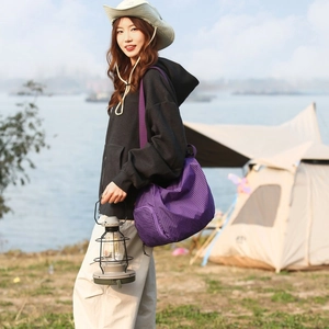 Détail du sac en toile à carreaux violets avec bandoulière réglable en camping extérieur
