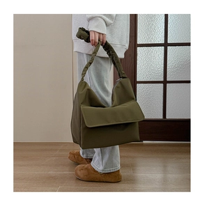 Close-up of olive green nylon tote bag with trendy ruched handle and minimalist flap