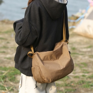 Vue détaillée du sac cabas à carreaux marron avec bandoulière réglable et zip latéral
