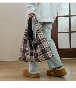 Brown and beige plaid tote bag styled on shoulder showing its large capacity and texture