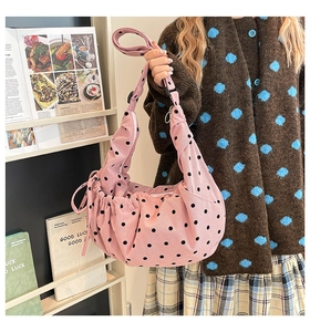 Détail du sac à bandoulière en velours rose à pois avec texture plissée et cordon latéral