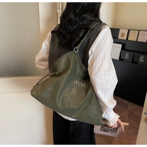 Close-up of olive green tote with Maodi lettering and daisy embroidery detail