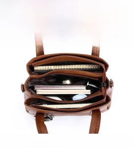 Deep brown textured leather handbag with multiple compartments showing high storage capacity