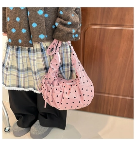 Détail du sac cabas en velours rose à pois noirs avec un design plissé
