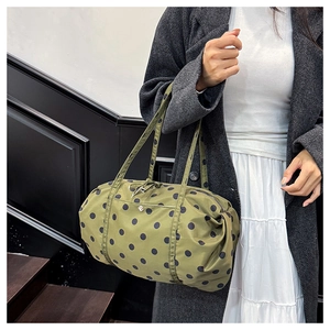 Détail de grands pois noirs sur un sac de voyage léger en nylon vert olive