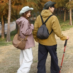 Vue extérieure d'un sac bandoulière à carreaux et d'un sac à dos sur l'herbe d'automne