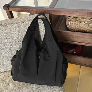 Große schwarze minimalistische Nylon-Tragetasche mit Seitentaschen und weichem Griff