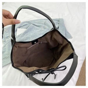 Internal view of black nylon tote bag featuring brown lining and a zippered pocket