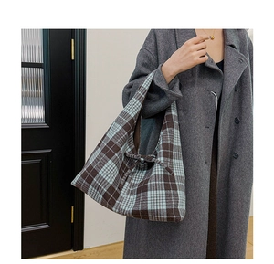 Detail view of a vintage plaid tote bag with ribbon bow and thick woven texture