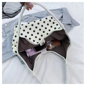 Spacious polka dot tote bag showing interior capacity with phone and accessories