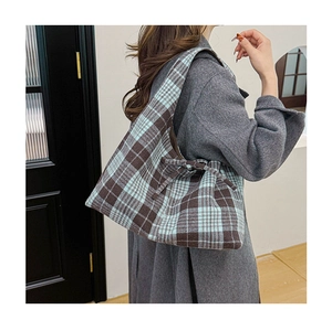Detail of plaid tote bag with decorative bow and thick textured fabric for autumn