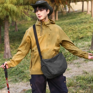 Détail d'une veste d'extérieur jaune moutarde et d'un sac bandoulière à carreaux noir et blanc