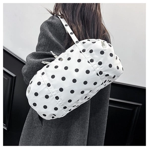 Gros plan détaillé d'un grand sac à bandoulière blanc à pois noirs en nylon résistant