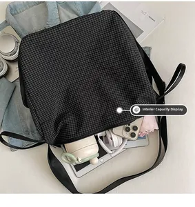Spacious interior of black checkerboard shoulder bag holding tablet and daily essentials