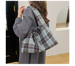 Detailed view of the large plaid tote bag in brown and light blue on a model