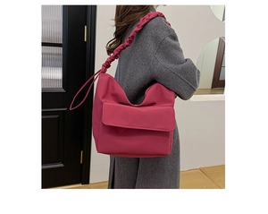 Rose red nylon messenger bag detail featuring creative pleated shoulder strap on model