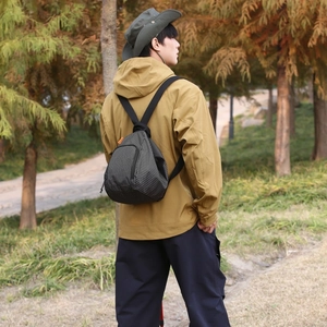 Détail du sac bandoulière léger en toile à carreaux sur un mannequin dans un parc d'automne