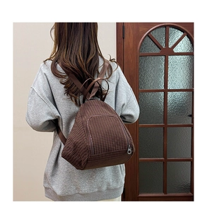 Close-up of deep brown checkered backpack with durable texture and zipper pocket