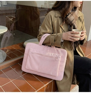 Pink corduroy laptop backpack detail with fine vertical texture and large front pocket