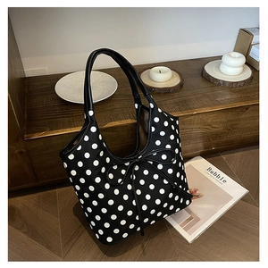 Polka dot nylon tote bag with bow detail displayed in a minimalist home setting