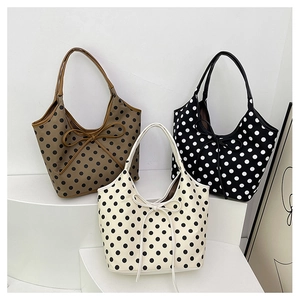 Three stylish polka dot nylon crossbody bags in black, white, and brown on white pedestals