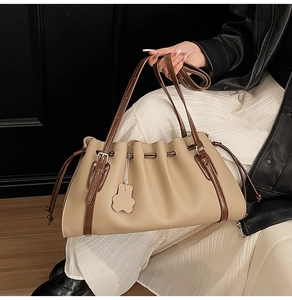 Detail of the pleated tote bag with pebble leather texture and cute bear charm