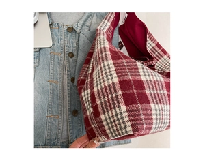 Detail of red and white plaid tote bag texture on denim jacket background