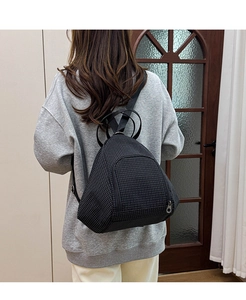 Detail view of the black plaid dumpling bag worn on back showing large capacity and style