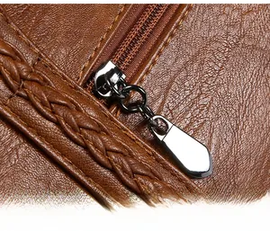 Detail of smooth silver zipper and woven leather texture on a vintage brown handbag