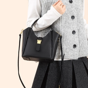 Détail du sac seau en cuir grainé noir avec fermoir doré et bandoulière réglable