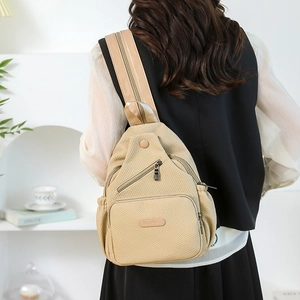Sac de poitrine en toile beige pour femme avec poches zippées et bandoulière réglable