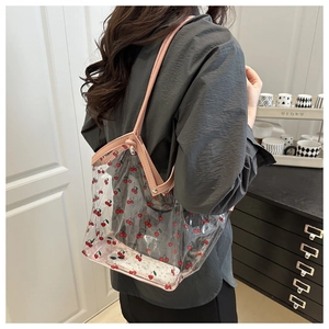 Dettaglio della borsa tote in PVC trasparente con stampa ciliegie e manici rosa