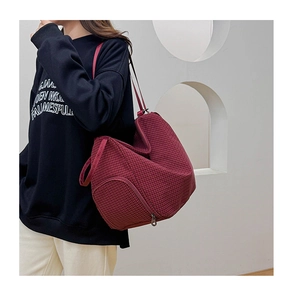 Detail of burgundy checkered shoulder bag featuring large capacity and side zipper pocket