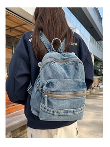 Photo de rue d'un sac à dos vintage en jean bleu clair avec poches porté sur le dos
