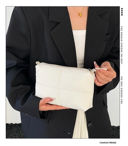 Close-up of white quilted cloud makeup bag with puffer texture and zipper detail