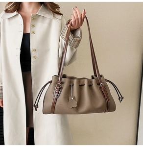Detail of vintage pleated clay tote bag with lychee texture and silver buckle strap