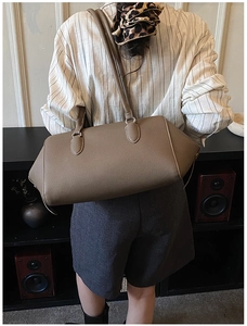 Dettaglio della pelle martellata di una grande borsa bowling color marrone caffè