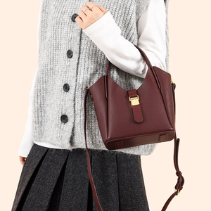 Détail du sac seau bordeaux en cuir grainé avec fermoir métallique doré élégant