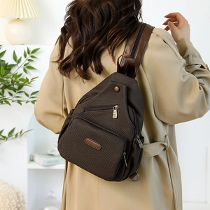 Détail du sac de poitrine en toile marron foncé avec motif à losanges et poches zippées