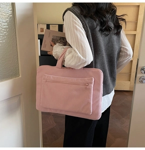 Pink corduroy laptop bag with a large front pocket and comfortable carrying handle