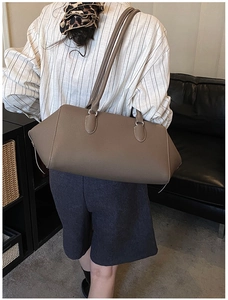 Dettaglio borsa in pelle marrone caffè con tracolle lunghe e design laterale a trapezio