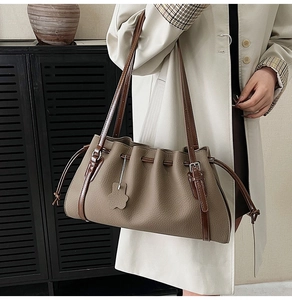 Close-up of vintage khaki tote bag with pleated design and brown leather straps