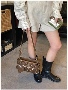 Detail der Retro-Umhängetasche mit Polka-Dots, Reißverschlusstaschen und Herzanhänger