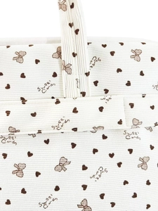 Close-up of beige corduroy shoulder bag with brown heart, bow patterns and Sweet Candy print